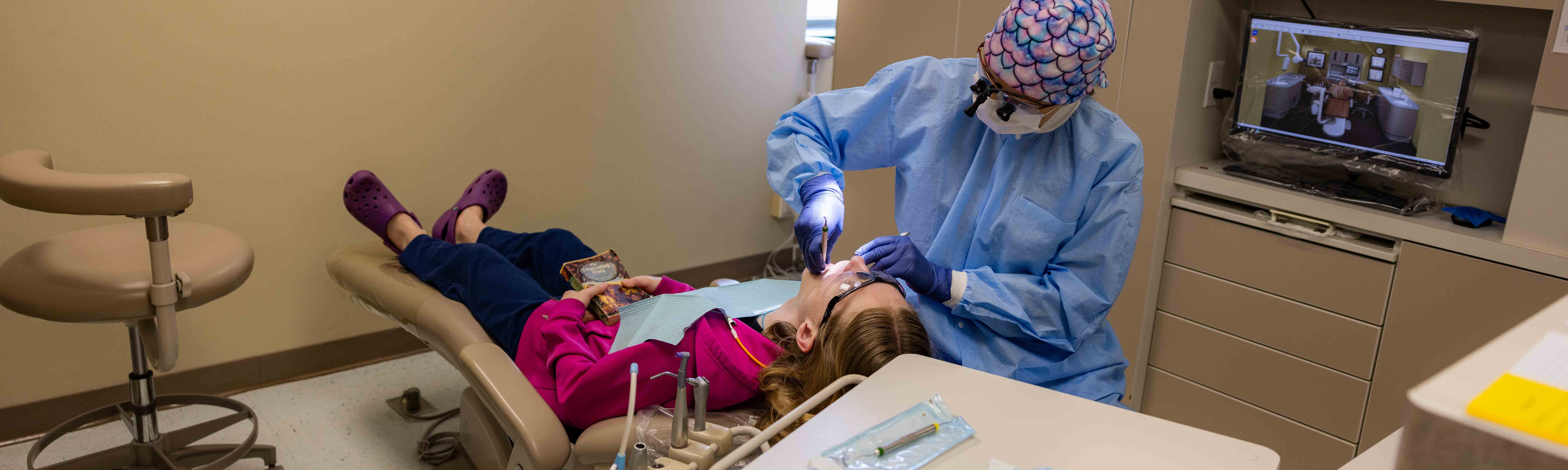 A Dental Hygiene students examines a child's teeth.