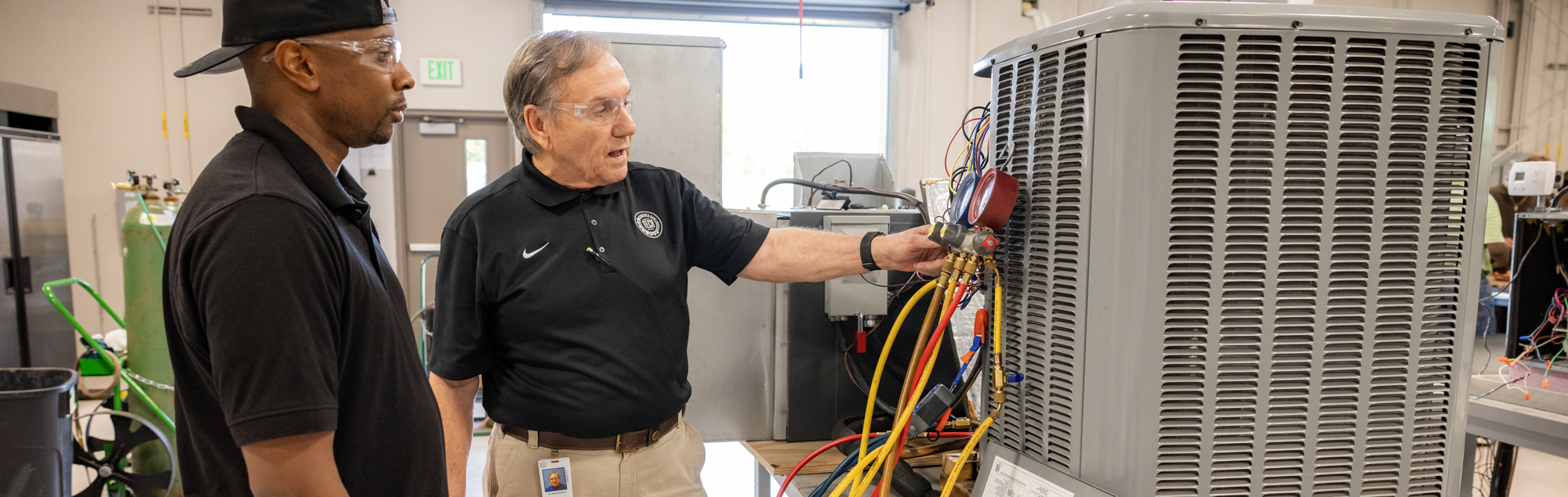 A FDTC instructor shows a HVAC student how to troubleshoot an air conditioning unit in the HVAC lab