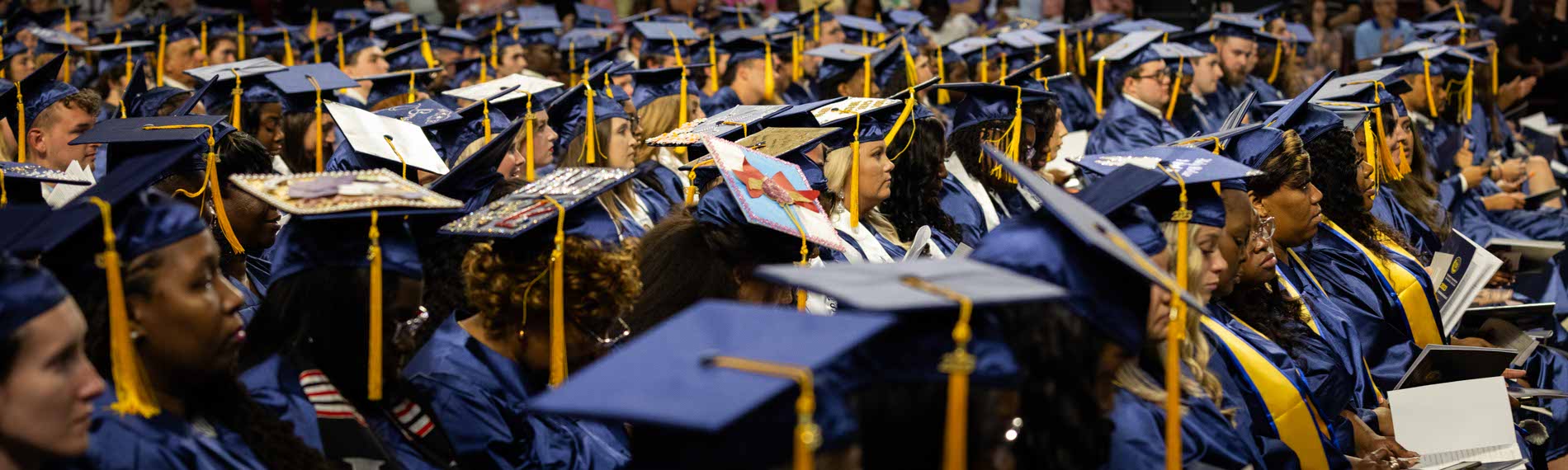 A large body of FDTC students sits at graduation in their caps and gowns.