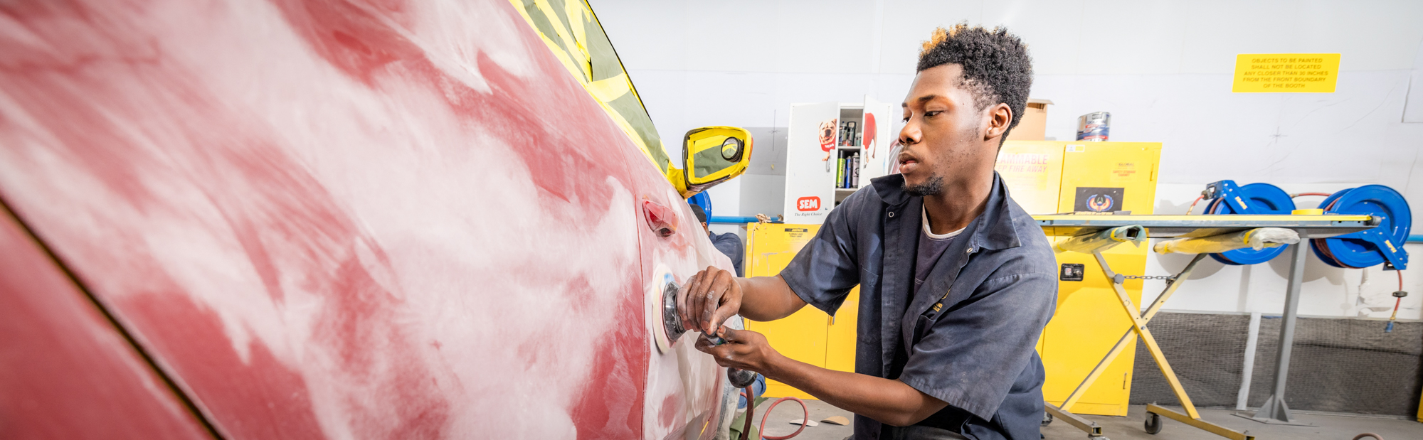 FDTC autobody repair student works on repairing a car in the paint shop