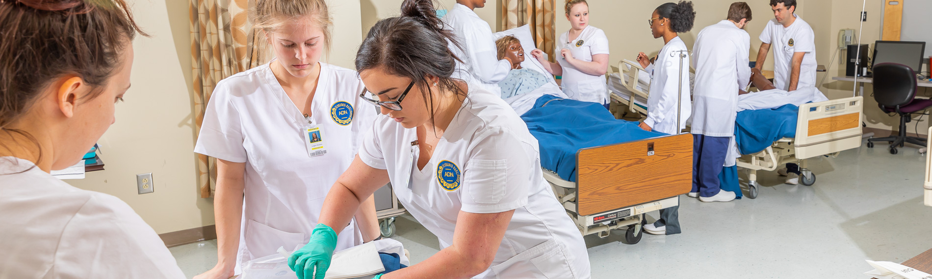 Nursing students practice in a hospital like classroom