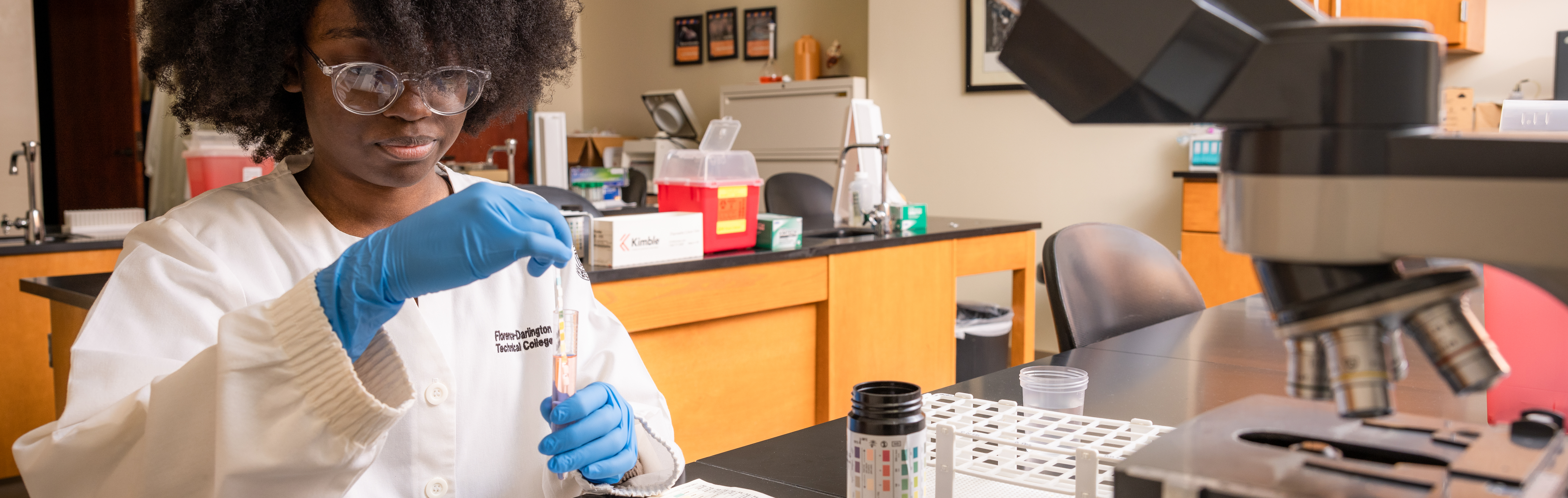 Image of student holding a testing tube in classroom.