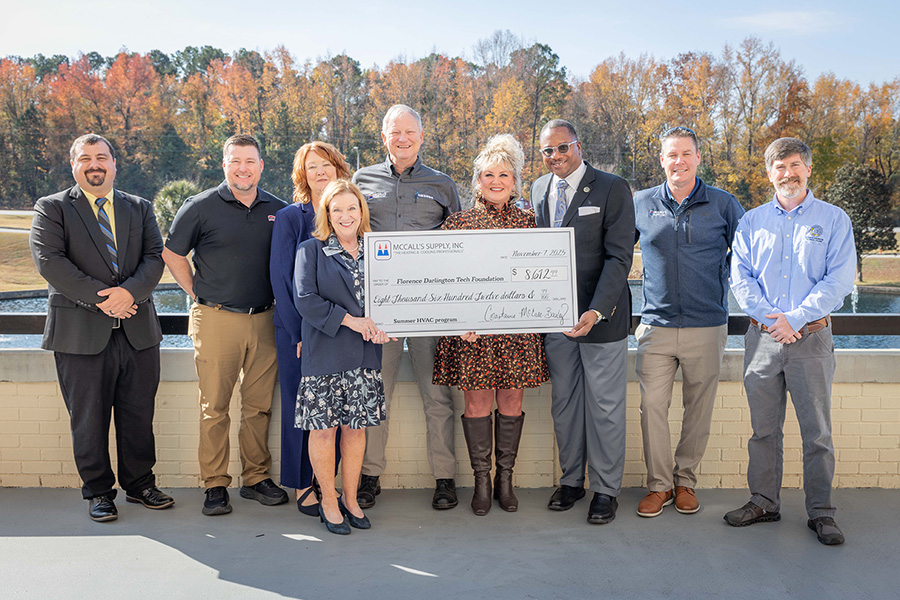An image of FDTC officials and representatives from McCall's Supply, Inc holding a giant donation check.