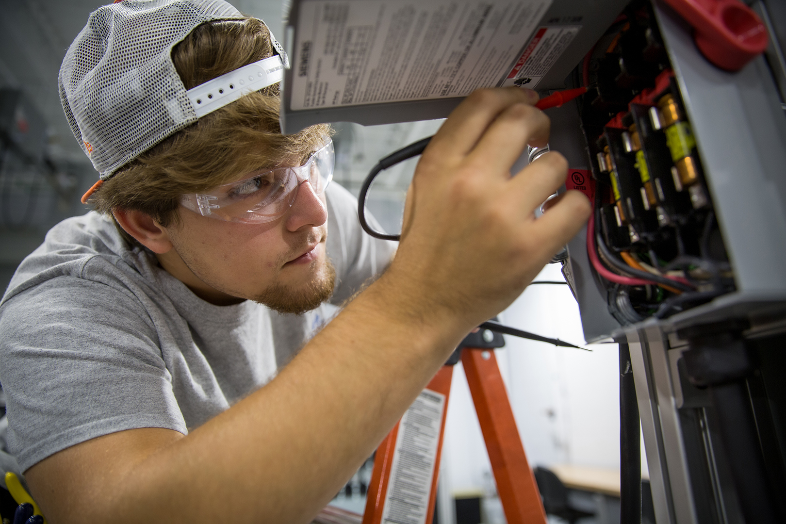 Student working on electrical equipment in class