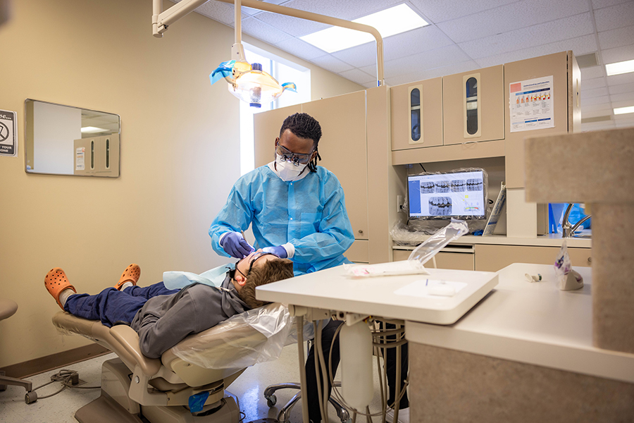 A dental hygienist student at FDTC examining a person's teeth