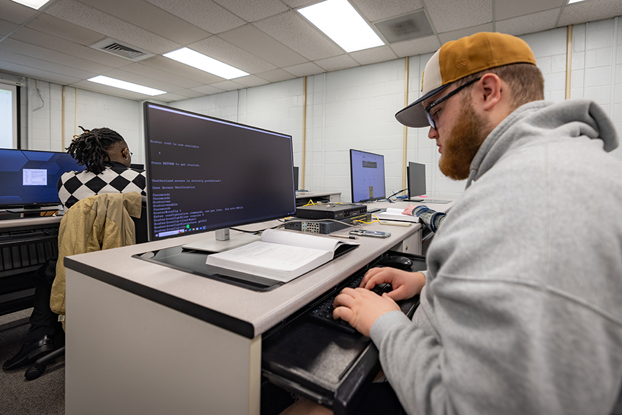 a student works on IT homework at a computer in a computer lab