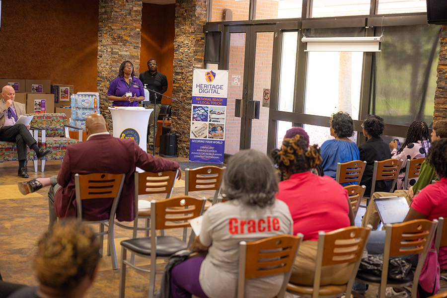 A speaker at a podium talks to a crowd of people in the student center of the 5000 building on the campus of Florence-Darlington Technical College.