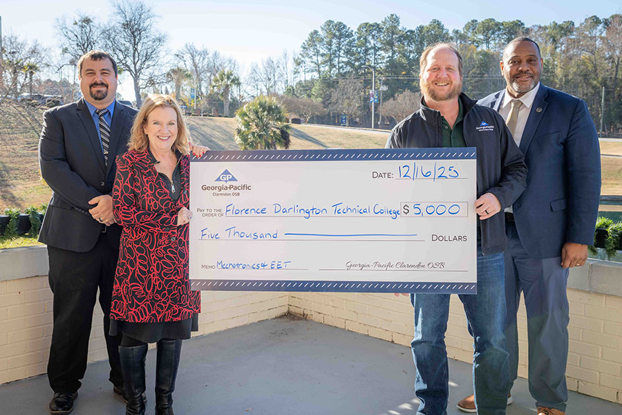 A georgia pacific representative presents a giant check donation to representatives of FDTC