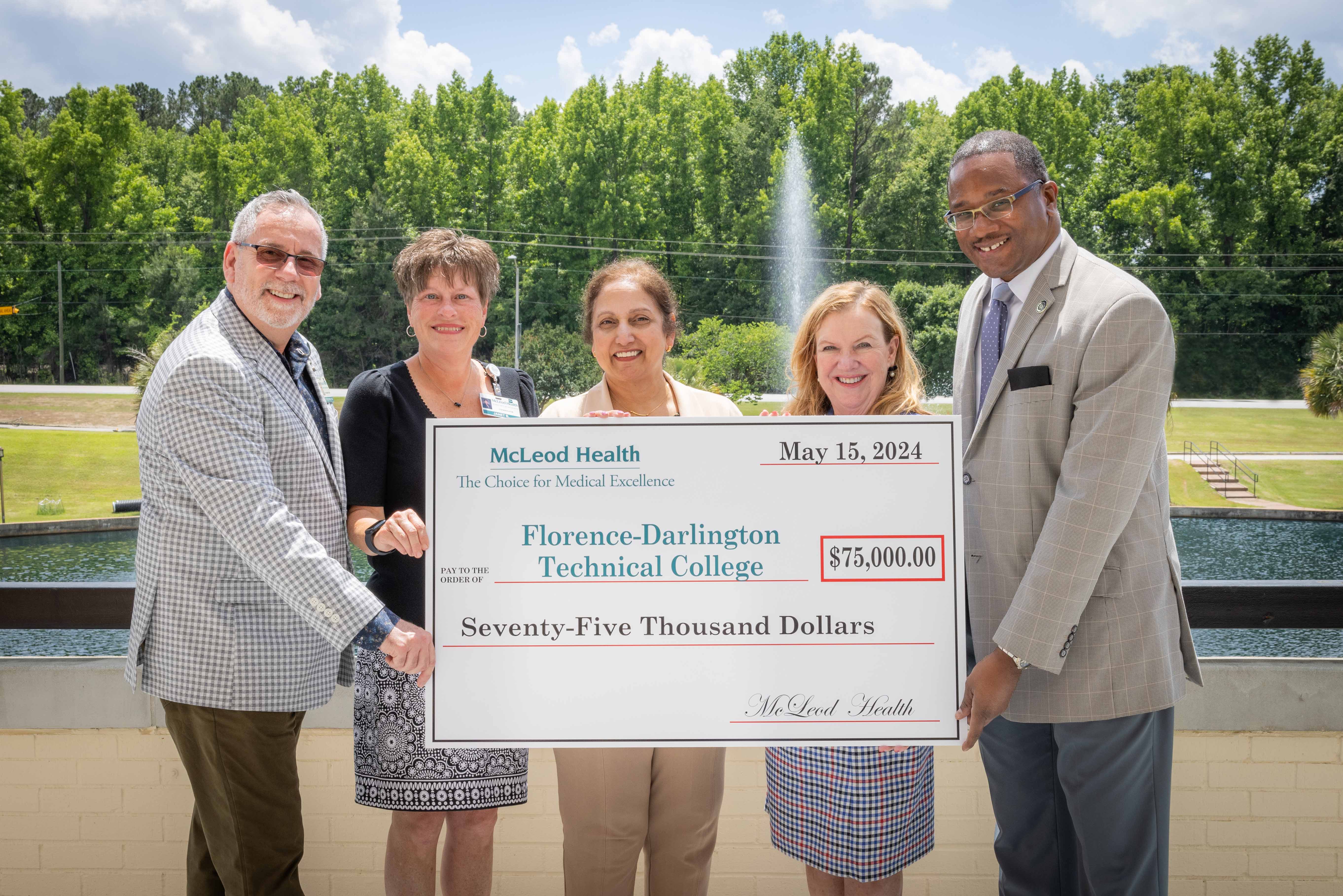 McLeod Health and FDTC officials hold McLeod's $75,000 donation check.