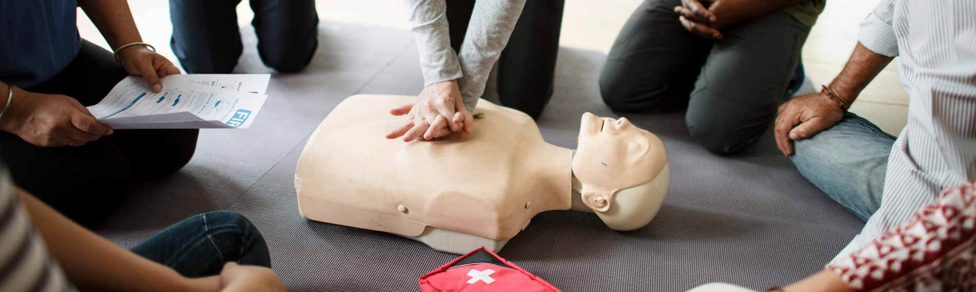 A group of students trains on a CPR manikin.